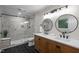 Beautiful bathroom featuring double sinks, two mirrors, wood cabinets and a tiled shower at 4705 Bernie Pl, Raleigh, NC 27616
