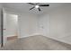 Cozy bedroom features neutral paint and carpet, a ceiling fan, and double closets with ample natural light at 4705 Bernie Pl, Raleigh, NC 27616