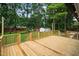 Lovely wooden deck overlooking backyard with string lights and mature trees at 4705 Bernie Pl, Raleigh, NC 27616