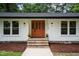 Inviting entryway with brick steps, decorative plants, and a brightly colored front door at 4705 Bernie Pl, Raleigh, NC 27616