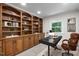 Comfortable home office features custom built-in wood shelving with a modern work desk at 4705 Bernie Pl, Raleigh, NC 27616