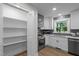 Kitchen pantry and white cabinets with grey backsplash at 4705 Bernie Pl, Raleigh, NC 27616