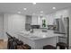 Bright kitchen boasts white cabinets, stainless steel appliances, quartz countertops and an island with seating at 4705 Bernie Pl, Raleigh, NC 27616