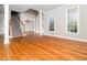 Bright living room with hardwood floors, crown molding, and large windows at 4916 Brambleridge Ct, Holly Springs, NC 27540