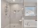 Bathroom with a glass enclosed shower, soaking tub and built in shelving at 492 Arlie Ln, Lillington, NC 27546