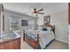 Bedroom with decorative wooden bed frame, ceiling fan, and two windows at 492 Arlie Ln, Lillington, NC 27546