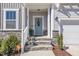 Inviting front entrance with stone steps and a light blue door with a decorative sunflower wreath at 492 Arlie Ln, Lillington, NC 27546