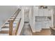 Hallway with stairs, wood floors, a rug runner, and an entry door in view, leading into the home at 492 Arlie Ln, Lillington, NC 27546