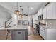 Modern kitchen with stainless steel appliances, island seating, and white cabinets at 492 Arlie Ln, Lillington, NC 27546