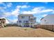 View of the home's rear exterior, with a back deck, patio, and expansive backyard at 492 Arlie Ln, Lillington, NC 27546