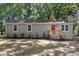 Charming one-story home with gray siding, red front door, and well-maintained landscaping at 567 Howard Tant Rd, Zebulon, NC 27597