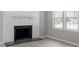 Close-up of the living room fireplace with windows, and light colored wood floors at 567 Howard Tant Rd, Zebulon, NC 27597