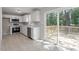 Kitchen features white cabinets, stainless steel appliances, and a large sliding glass door that leads to an outdoor deck at 567 Howard Tant Rd, Zebulon, NC 27597
