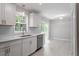 Well-lit kitchen featuring white cabinets, stainless steel appliances, and new light colored wood floors at 567 Howard Tant Rd, Zebulon, NC 27597