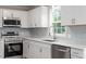 Beautifully remodeled kitchen with white cabinets, stainless steel appliances, and gray subway tile backsplash at 567 Howard Tant Rd, Zebulon, NC 27597