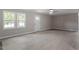 Bright living room with new light colored floors, front windows, and a front door at 567 Howard Tant Rd, Zebulon, NC 27597