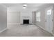 Bright and airy living room with fireplace, new flooring, and a front entry door at 567 Howard Tant Rd, Zebulon, NC 27597