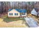 A yellow home with blue shutters on a large lot among the trees near a concrete driveway at 5748 Presentation St, Knightdale, NC 27545