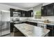 Well-lit kitchen featuring stainless steel appliances, granite countertops, and dark wood cabinets at 64 Delcarso Ct, Lillington, NC 27546