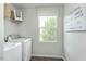 Functional laundry room with modern washer and dryer, ample natural light and shelving at 64 Delcarso Ct, Lillington, NC 27546
