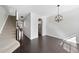 Bright living room with hardwood floors, staircase, and modern light fixture at 684 Wickham Ridge Rd, Apex, NC 27539