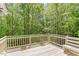 Back porch featuring wooden railing and bench with view of lush trees in a beautiful surrounding nature at 703 Caswell Rd, Chapel Hill, NC 27514