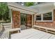 Cozy brick porch with sliding glass door and wooden benches, perfect for enjoying the outdoors at 703 Caswell Rd, Chapel Hill, NC 27514