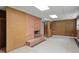 Wide angle of the basement with retro paneling, exposed brick, and a fireplace at 703 Caswell Rd, Chapel Hill, NC 27514