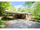Home exterior view with a carport and stone facade surrounded by greenery at 703 Caswell Rd, Chapel Hill, NC 27514