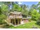 Home exterior view with a deck, brick facade, and large windows surrounded by greenery at 703 Caswell Rd, Chapel Hill, NC 27514