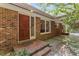 Inviting brick home exterior with covered porch and wooden front door at 703 Caswell Rd, Chapel Hill, NC 27514
