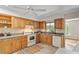 Bright kitchen with wooden cabinets, white appliances, and a window to the outdoors at 703 Caswell Rd, Chapel Hill, NC 27514