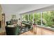 Bright living room with hardwood floors, floor-to-ceiling windows, and stylish furnishings with a brick fireplace at 703 Caswell Rd, Chapel Hill, NC 27514