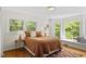 Bedroom with natural light, hardwood floors, and a cozy window seat overlooking the trees at 703 Caswell Rd, Chapel Hill, NC 27514