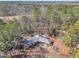 Stunning aerial view of a house nestled among tall pine trees, showcasing its metal roof and brick driveway at 723 Chelsea Dr, Sanford, NC 27332