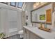 Bright bathroom featuring a skylight, a large mirror, and a shower with a curtain at 723 Chelsea Dr, Sanford, NC 27332