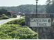 Stone entrance sign to Carolina Trace community featuring lush landscaping and winding roads at 723 Chelsea Dr, Sanford, NC 27332