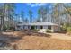 Ranch style home with metal roof and mature trees on a lot covered with pine needles at 723 Chelsea Dr, Sanford, NC 27332