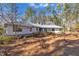 Ranch style home with metal roof and mature trees on a lot covered with pine needles at 723 Chelsea Dr, Sanford, NC 27332