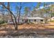 Ranch style home with metal roof and mature trees on a lot covered with pine needles at 723 Chelsea Dr, Sanford, NC 27332
