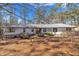 Charming single-story home features a metal roof, inviting facade, and a lush yard with mature landscaping at 723 Chelsea Dr, Sanford, NC 27332