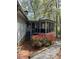 Charming home exterior with screened-in porch and flowering bushes in a wooded setting at 723 Chelsea Dr, Sanford, NC 27332