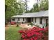 Inviting home exterior with lush landscaping, flowering bushes, and a charming brick walkway at 723 Chelsea Dr, Sanford, NC 27332