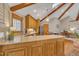 Bright kitchen features wood cabinets, stainless steel appliances, island, and wood beam vaulted ceiling at 723 Chelsea Dr, Sanford, NC 27332