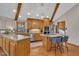 Bright kitchen features wood cabinets, stainless steel appliances, island, and wood beam vaulted ceiling at 723 Chelsea Dr, Sanford, NC 27332