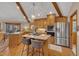 Bright kitchen features wood cabinets, stainless steel appliances, island, and wood beam vaulted ceiling at 723 Chelsea Dr, Sanford, NC 27332
