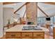 Bright kitchen features wood cabinets, island with cooktop, brick fireplace, and desk at 723 Chelsea Dr, Sanford, NC 27332