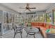 Enclosed porch with orange sofa and ceiling fan; perfect for enjoying the outdoors at 723 Chelsea Dr, Sanford, NC 27332