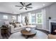 Spacious living area with a fireplace, a ceiling fan, and abundant natural light from multiple windows at 724 Denburn Pl, Raleigh, NC 27603