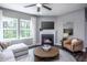 Cozy living room with a fireplace, a ceiling fan, and lots of natural light at 724 Denburn Pl, Raleigh, NC 27603